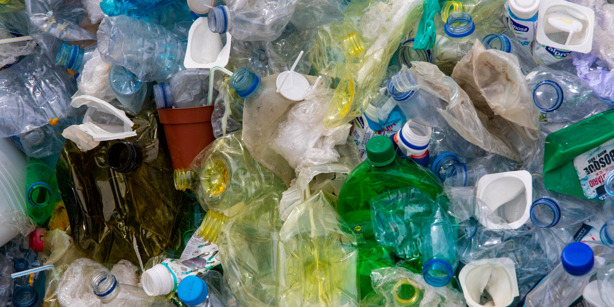 A pile of plastic bottles which have been squished and are intended for recyling.